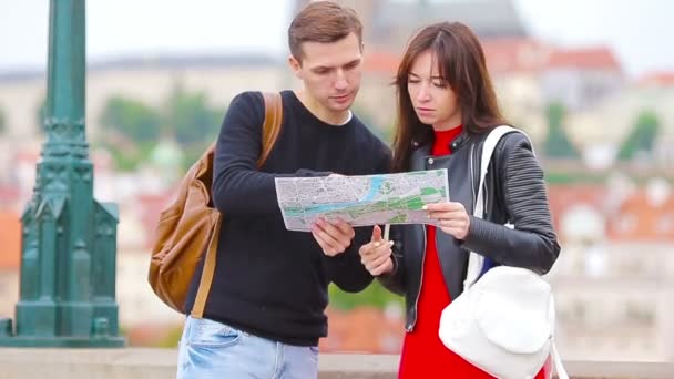 Mladý turistický pár cestující na dovolenou v Evropě se šťastně usmívá. Kavkazská rodina s mapou města při hledání zajímavostí - Záběry, video
