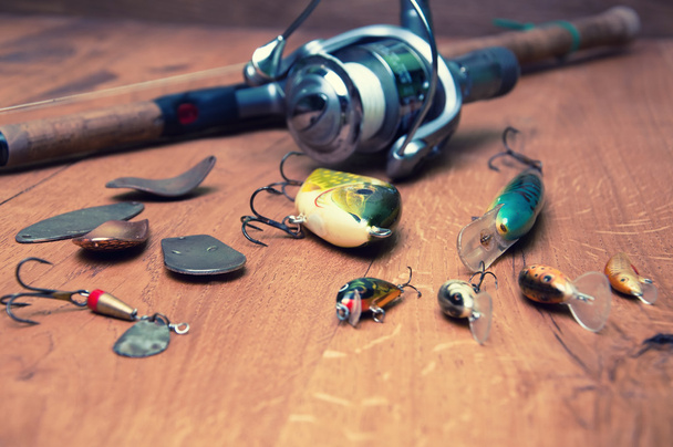 Fishing baits and rod isolated on wooden background - Photo, Image