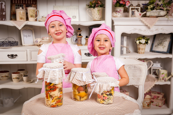 Young cook hostesses with tasty bottled food - Foto, imagen