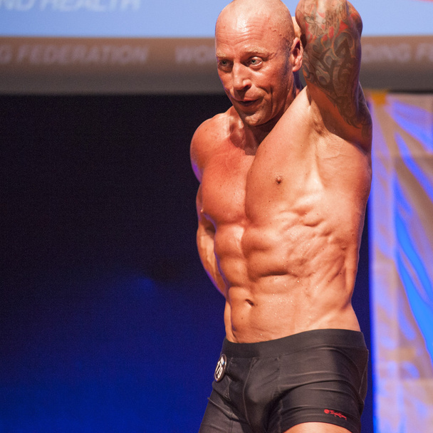 Maschio bodybuilder mostra il suo meglio in campionato sul palco
 - Foto, immagini