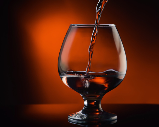 cognac pouring into glass - Foto, Bild