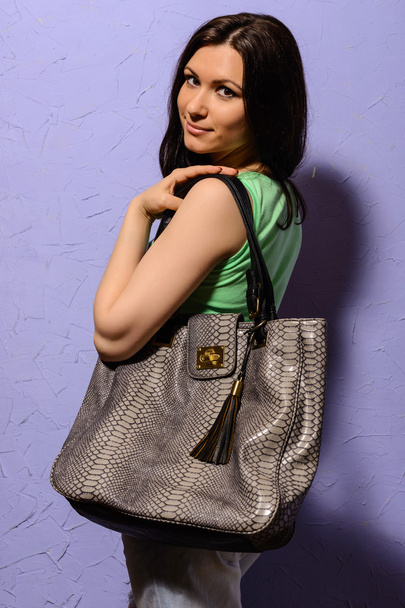 Ελκυστική μελαχρινή κοπέλα με μεγάλη τσάντα από δέρμα φιδιού - Φωτογραφία, εικόνα