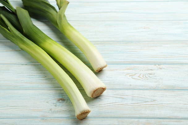 Green leeks on wooden table - Photo, Image