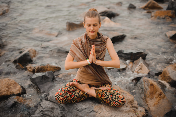 Woman meditating at the beach . yoga retreat. namaste in lotus pose - Foto, Bild