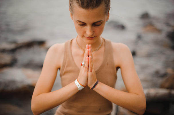 beautiful woman performing namaste gesture with closed eyes - Photo, image
