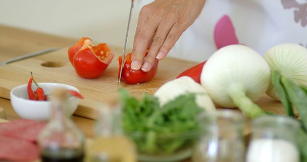 Hausfrau hackt frische rote Paprika - Foto, Bild