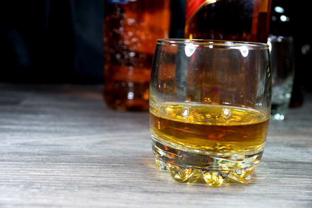 Whiskey glass and bottles in a bar - Photo, image