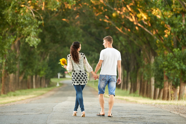 幸せな若いカップル歩く国道路屋外、ロマンチックな人々 の概念、夏のシーズン - 写真・画像