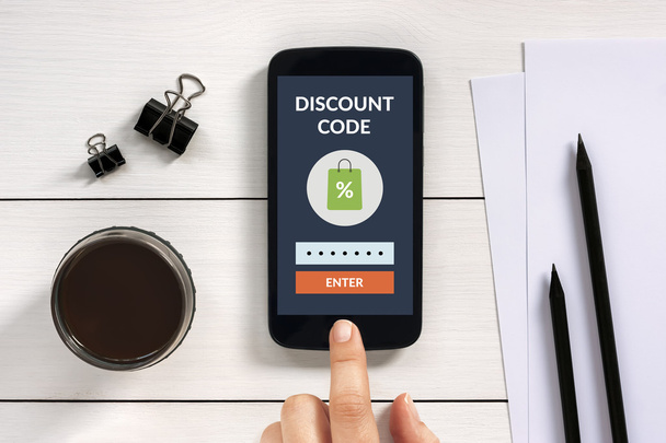 Discount code concept on smart phone screen with office objects - Photo, Image