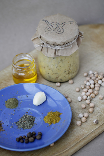 Zelfgemaakte hummus in pot met ingrediënten - Foto, afbeelding