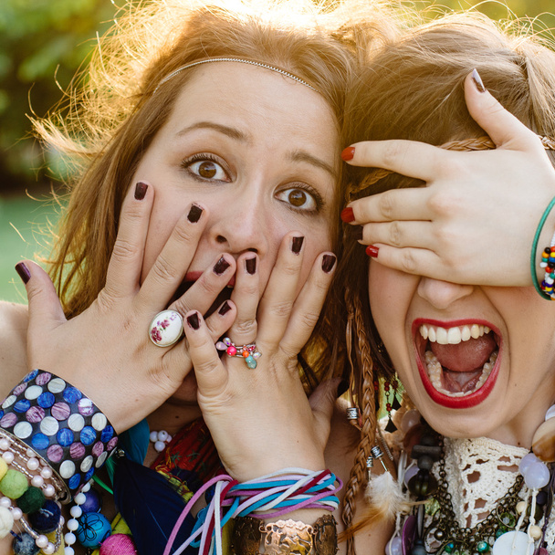 Close up fashion portrait of Two friends have fun , make grimaces ,fun emotions and shows hand signs. Pretty girls wearing summer clothes - Photo, Image