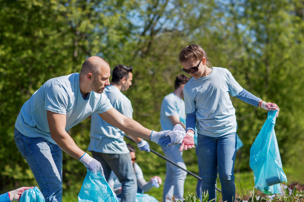 volunteers with garbage bags cleaning park area - Фото, зображення