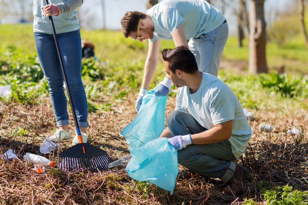 volunteers with garbage bags cleaning park area - Zdjęcie, obraz
