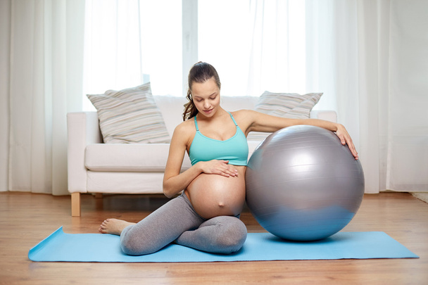 mujer embarazada feliz con fitball en casa - Foto, Imagen
