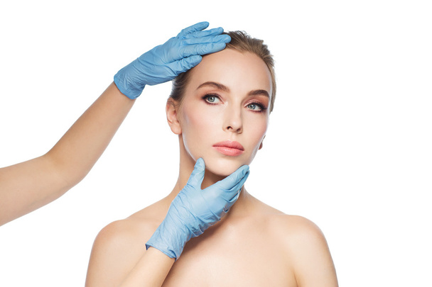 chirurg of schoonheidsspecialiste handen aanraken van gezicht vrouw - Foto, afbeelding