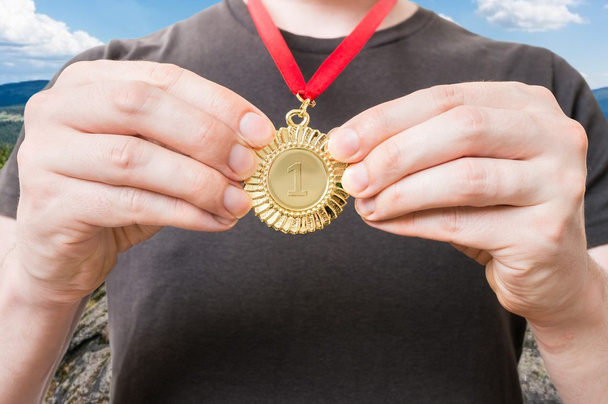 Sportsman or winner is showing his award - golden medal. - Photo, Image