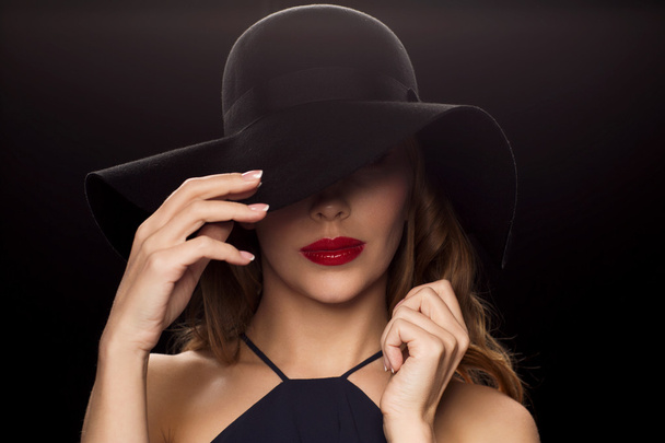 beautiful woman in black hat over dark background - Фото, зображення
