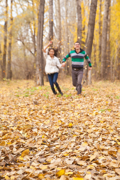 Young latin hispanic couple holding hands and running in autumn park  - Φωτογραφία, εικόνα