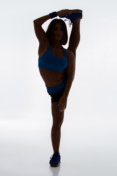 Menina flexível desportiva fazendo exercício de alongamento
 - Foto, Imagem