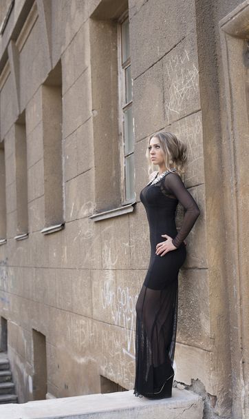 Portrait of Beautiful young adult caucasian woman standing by old concrete wall  - Zdjęcie, obraz