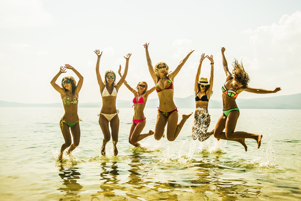 vista de Grupo de Amigos se divertindo na praia tropical no verão. hora de verão
 - Foto, Imagem