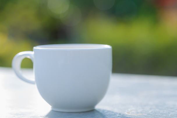 cup of coffee on  table in green garden - Zdjęcie, obraz