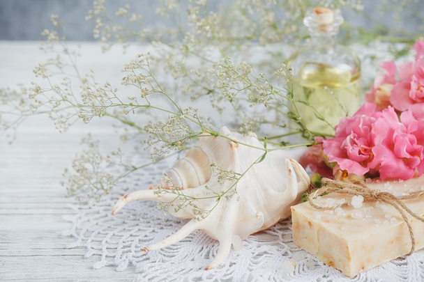 Natural handmade soap, aromatic oil and flowers on white wooden  - 写真・画像