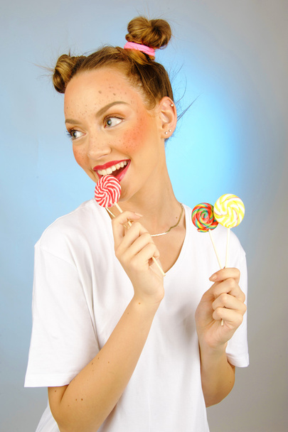 süßes Mädchen mit Süßigkeiten mit Fraktur auf backgrpund - Foto, Bild