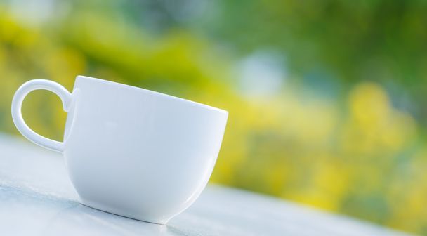 cup of coffee on  table in green garden - Foto, imagen