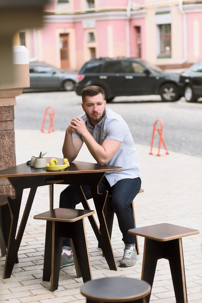Handsome man sitting in outdoor vegan cafe - Foto, immagini