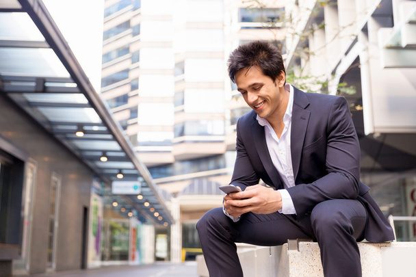 Portrait of confident businessman with mobile phone outdoors - Valokuva, kuva