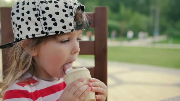 Κοριτσάκι να κάθεται στην καρέκλα και να τρώει παγωτό - Πλάνα, βίντεο
