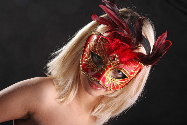 Обнажённая блондинка в венецианской маске на черном фоне
 - Фото, изображение