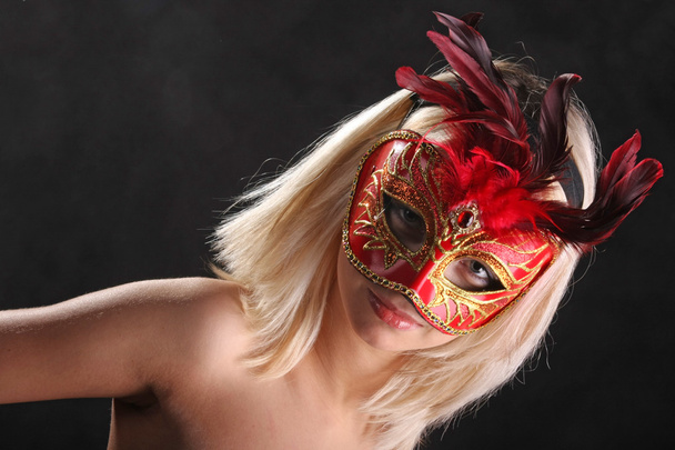 ξανθιά φλερτάρει στη βενετσιάνικη μάσκα σε μαύρο φόντο - Φωτογραφία, εικόνα
