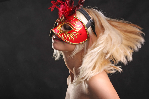 bionda in maschera con un bel collo su sfondo nero
 - Foto, immagini