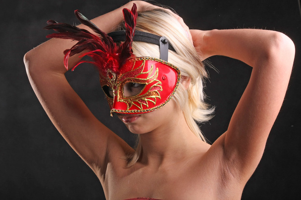 bionda in maschera con un bel collo su sfondo nero
 - Foto, immagini