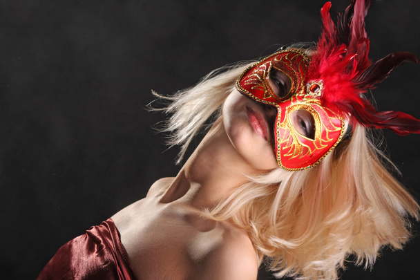 blonde in mask with a beautiful neck on black background - Photo, Image