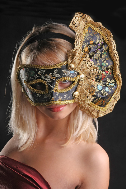 rubia coquetea en la máscara veneciana sobre fondo negro
 - Foto, imagen