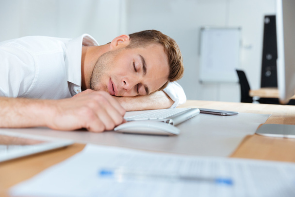 Уставший от усталости молодой бизнесмен спит на столе
 - Фото, изображение