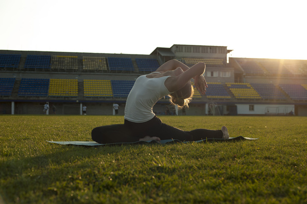 Thin flexible woman doing yoga in park - Foto, Imagen