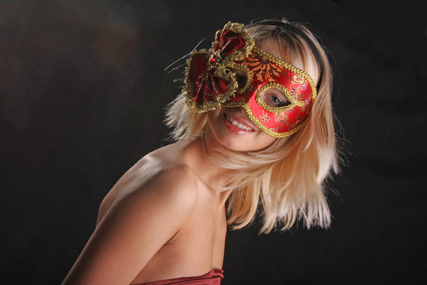 emotions on the face of the girl in the Venetian mask on black background - Фото, изображение