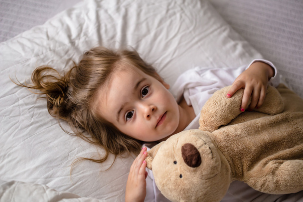 dziewczynka w łóżku z soft zabawka emocje dziecka - Zdjęcie, obraz