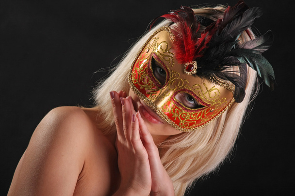 На обличчі дівчини з венеціанської маски на чорному фоні. - Фото, зображення