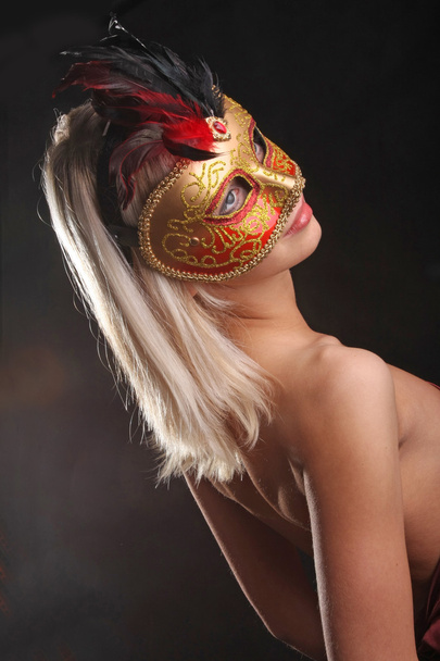 συναισθήματα στο πρόσωπο του κοριτσιού με τη βενετσιάνικη μάσκα σε μαύρο φόντο - Φωτογραφία, εικόνα