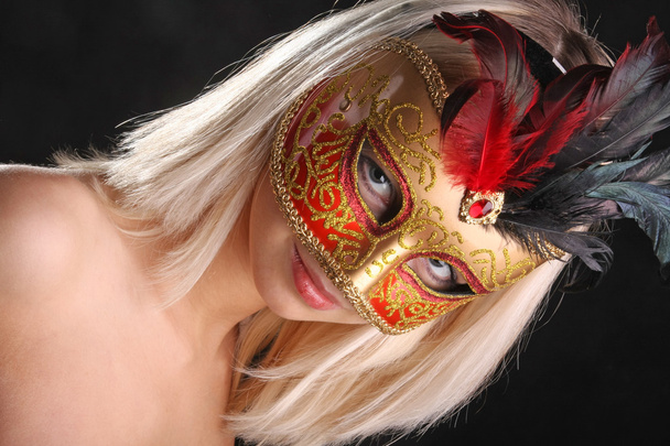 emotions on the face of the girl in the Venetian mask on black background - 写真・画像