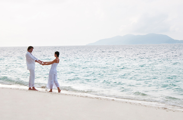 Picture of romantic young couple having a walking on the sea sho - Photo, Image