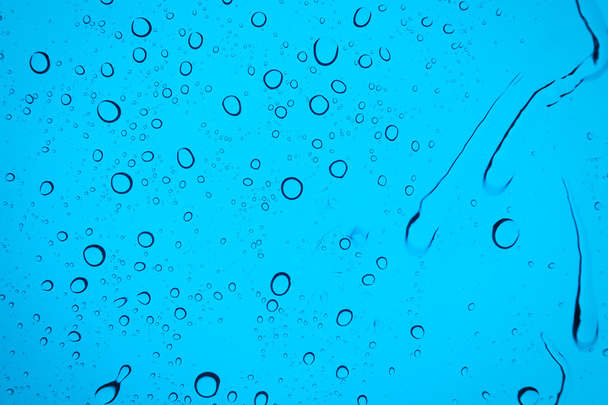 Water drops background. Water drops on glass window over blue sky - 写真・画像
