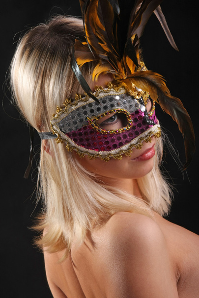 На обличчі дівчини з венеціанської маски на чорному фоні. - Фото, зображення