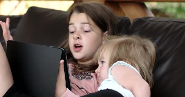 Two Little Girls Using Tablet Computer on Sofa on Terrace - Filmagem, Vídeo