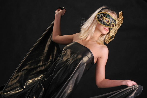 girl in black Venetian mask on dark background - Фото, изображение